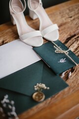 Vertical shot of a wedding invitation with a sealed envelope on the table