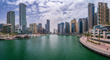 Panorama of tall apartment blocks surround the water at Dubai Marina in the UAE