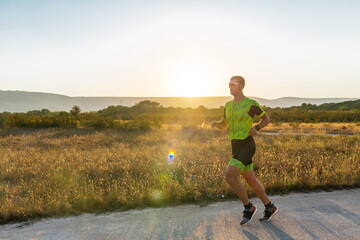 Triathlete in professional gear running early in the morning, preparing for a marathon, dedication...