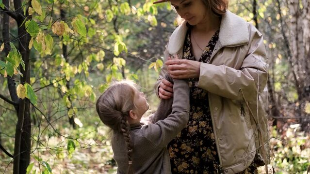Hello September. A young mother and little daughter walk in the city park in autumn.