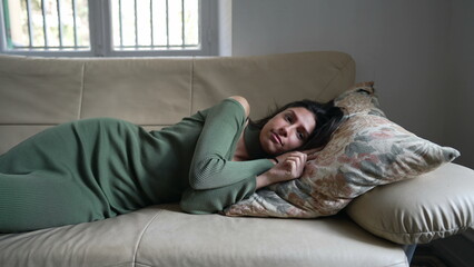 Relaxation time for a young Arab woman on the couch. Middle Eastern adult girl unwinding and de-stressing