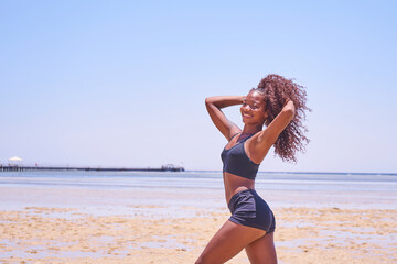 Fototapeta na wymiar oung smiling brazilian woman on summer vacation standing at beach and enjoying sea breeze.Sexy bikini body woman feeling free on holidays. 