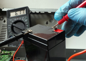 Accumulator maintenance for UPS. Full battery testing with Voltmeter.