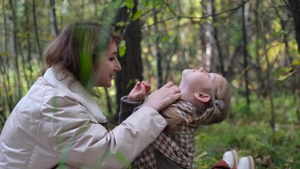 Hello September. A young mother and little daughter walk in the city park in autumn.