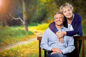 Fototapeta premium Elderly, happy couple on wooden bench in garden