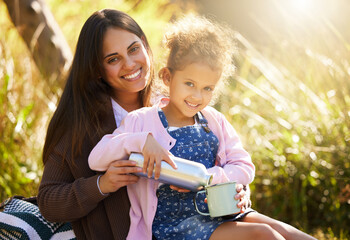 She just wants to help. Cropped portrait of an adorable little girl pouring her mother coffee from a flask during their picnic in the park.