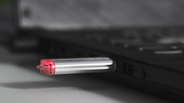 young woman plug usb flash drive into connector on computer, close-up