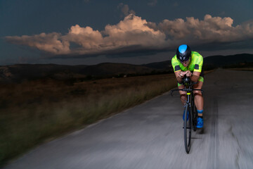 A triathlete rides his bike in the darkness of night, pushing himself to prepare for a marathon....