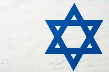 Independence Day of Israel. National Israel flag with star of David over white wooden background. Close up. National flag with place for text.