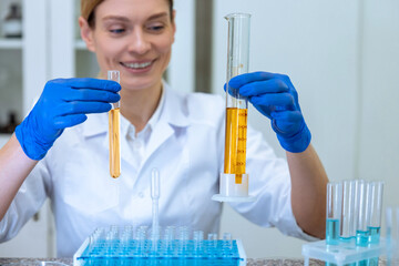 Woman biologist holding test tubes with yellow liquid in hands doing experiments in field of biology