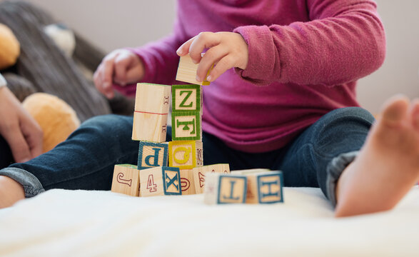 Let Todays Lessons Be Building Blocks For A Better Tomorrow. A Little Girl Stacking Blocks With Her Mother At Home.