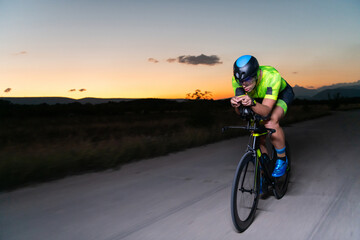 A triathlete rides his bike in the darkness of night, pushing himself to prepare for a marathon. The contrast between the darkness and the light of his bike creates a sense of drama and highlights the