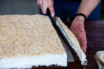 Housewife in the process of preparing delicious biscuit in the  kitchen - removing the edges