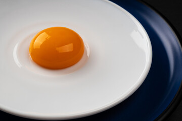 Egg yolk on the plate. Abstract fried eggs. Close up. 