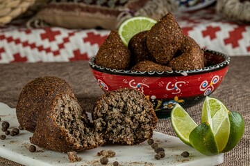 Bowl of fresh tasty Kibbeh and lime on the table