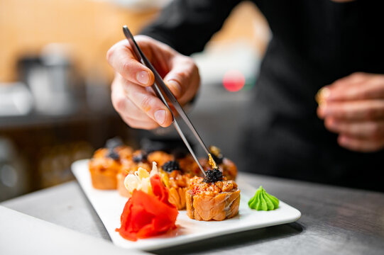 professional chef's hands making sushi and rolls in a restaurant kitchen