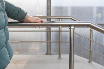 woman holding on to the railing going down the stairs.