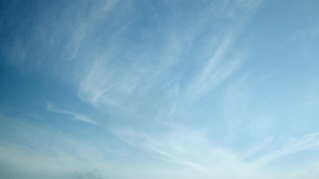 White, light, translucent cirrus clouds slowly drift across the clear blue sky, video timelapse, sky as a background.
