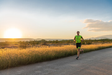 Obraz premium Triathlete in professional gear running early in the morning, preparing for a marathon, dedication to sport and readiness to take on the challenges of a marathon. 