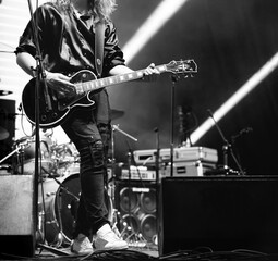 Guitarist on stage playing bass guitar at a rock concert