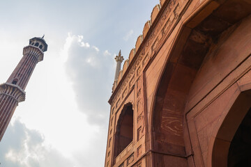 Courtyard entrance gate of jama masjid mosque made of red sandstone and typical arches symbolising...