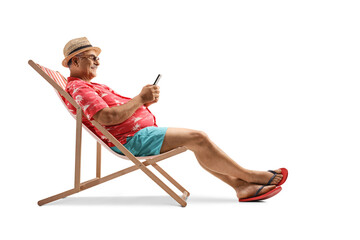Mature male tourist sitting on a beach chair with a smartphone