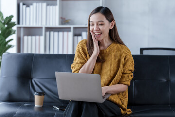 Using laptop pc, Pretty young asian woman housewife relax on comfortable sofa feels satisfied accomplish chores housework concept