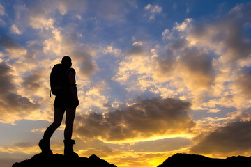 Hiker goes against sky and sun, a person standing on a rock with mountains in the background,  massive boots, during sunset, high detailed close up of, close up shot from the top, Generative AI