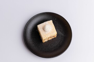 a plate with two squares of cake on it next to a jar of milk - obrazy, fototapety, plakaty