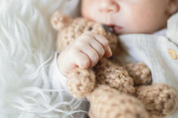 Ein schlafendes Baby hält ein Teddybär. 