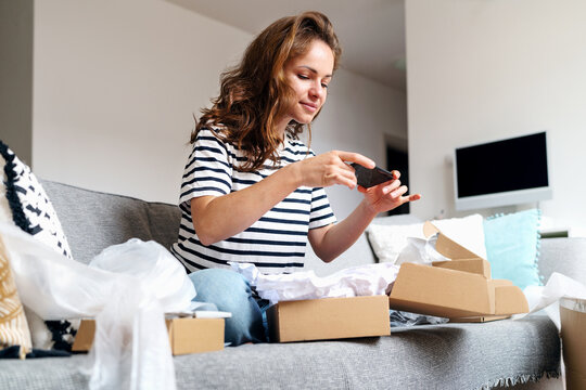 Woman taking picture of online purchase for leaving feedback about delivery and goods. Rating postal service, online shopping expirience.