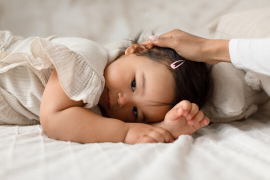 Japanese Baby Daughter Lying While Mom Stroking Her Head Indoor