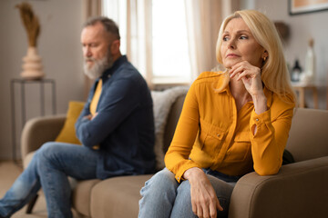 Naklejka na ściany i meble Unhappy Mature Couple Having Marital Crisis Sitting On Sofa Indoor