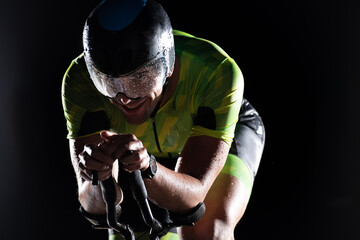 A triathlete rides his bike in the darkness of night, pushing himself to prepare for a marathon....