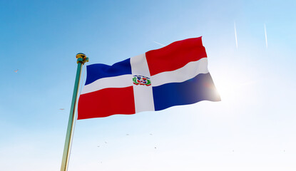 Flag of dominican republic waving in the wind, sky and sun background. Dominican Republic Flag.
