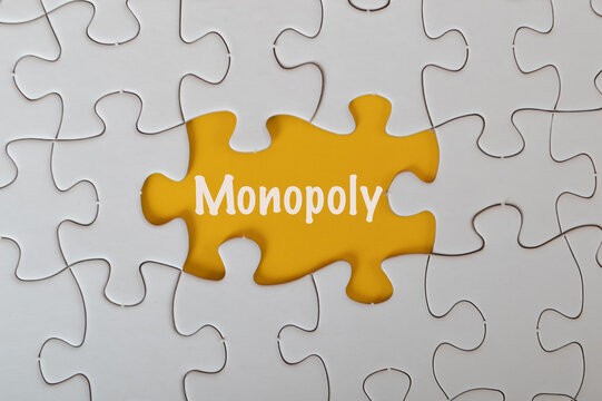 Missing jigsaw puzzle with text MONOPOLY isolated on a yellow background.