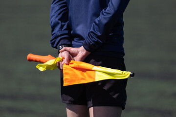 Un arbitre tient ses drapeaux dans son dos