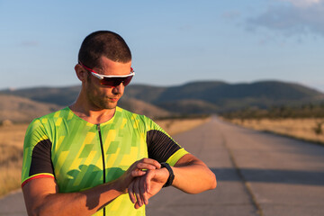 The triathlete checking his training statistics on a smartwatch, analyzing his performance and...