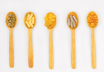 Variety of vitamin and dietary supplement pills on wooden spoons