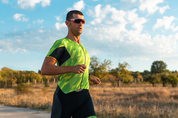 Fototapeta premium Triathlete in professional gear running early in the morning, preparing for a marathon, dedication to sport and readiness to take on the challenges of a marathon. 