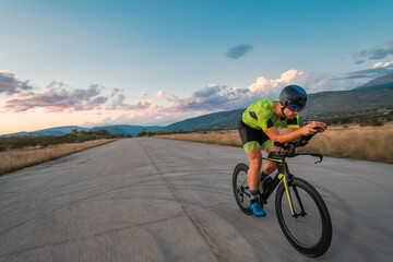 Fototapeta na wymiar Triathlete riding his bicycle during sunset, preparing for a marathon. The warm colors of the sky provide a beautiful backdrop for his determined and focused effort.