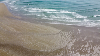 coast, sand and sea waves, top view. Sandy beach and ocean tide. Seascape. Aerial view of ocean waves