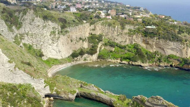 Aerial view on the Trentaremi bay of Posillipo, a district of Naples, Italy. There is a small empty beach in a cove. The coast overlooks the Mediterranean Sea.