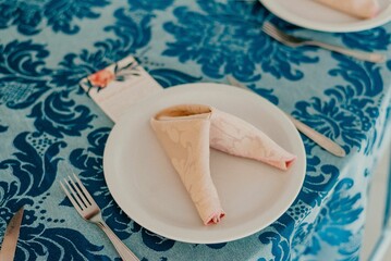 Modern minimalist wooden table featuring a white plate with silverware, perfectly set up for a meal