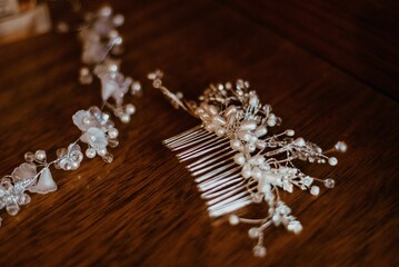 two combs with pearls and silver flowers on a table