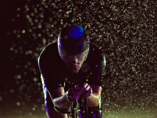 A triathlete braving the rain as he cycles through the night, preparing himself for the upcoming...