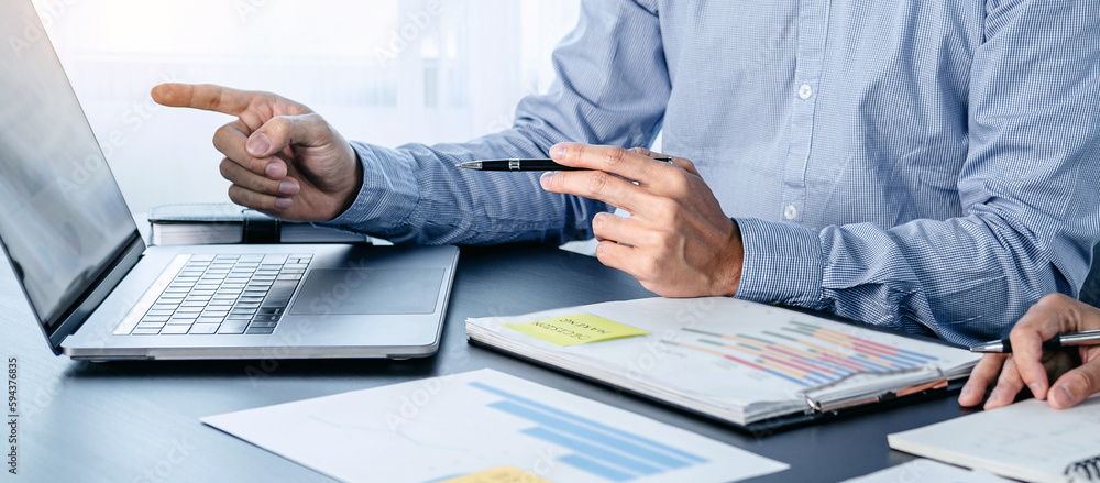 Poster two business colleagues pointing business data on laptop and tak