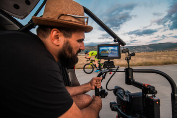 A videographer recording a triathlete riding his bike preparing for an upcoming marathon.Athlete's...