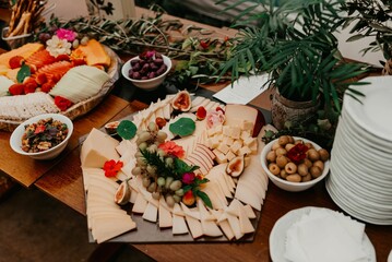 some plates of food on a wooden table next to plants and fruit