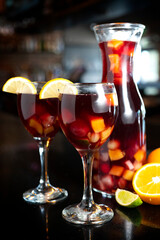 Red wine sangria on a pitcher with fruit and two cups